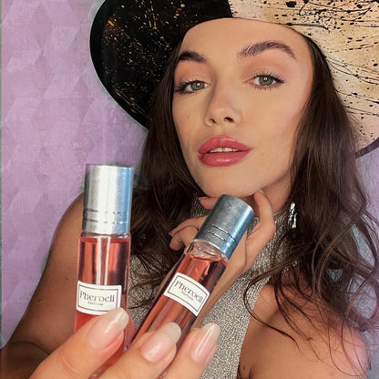 Donna che tiene due flaconi di profumo Pheroeli